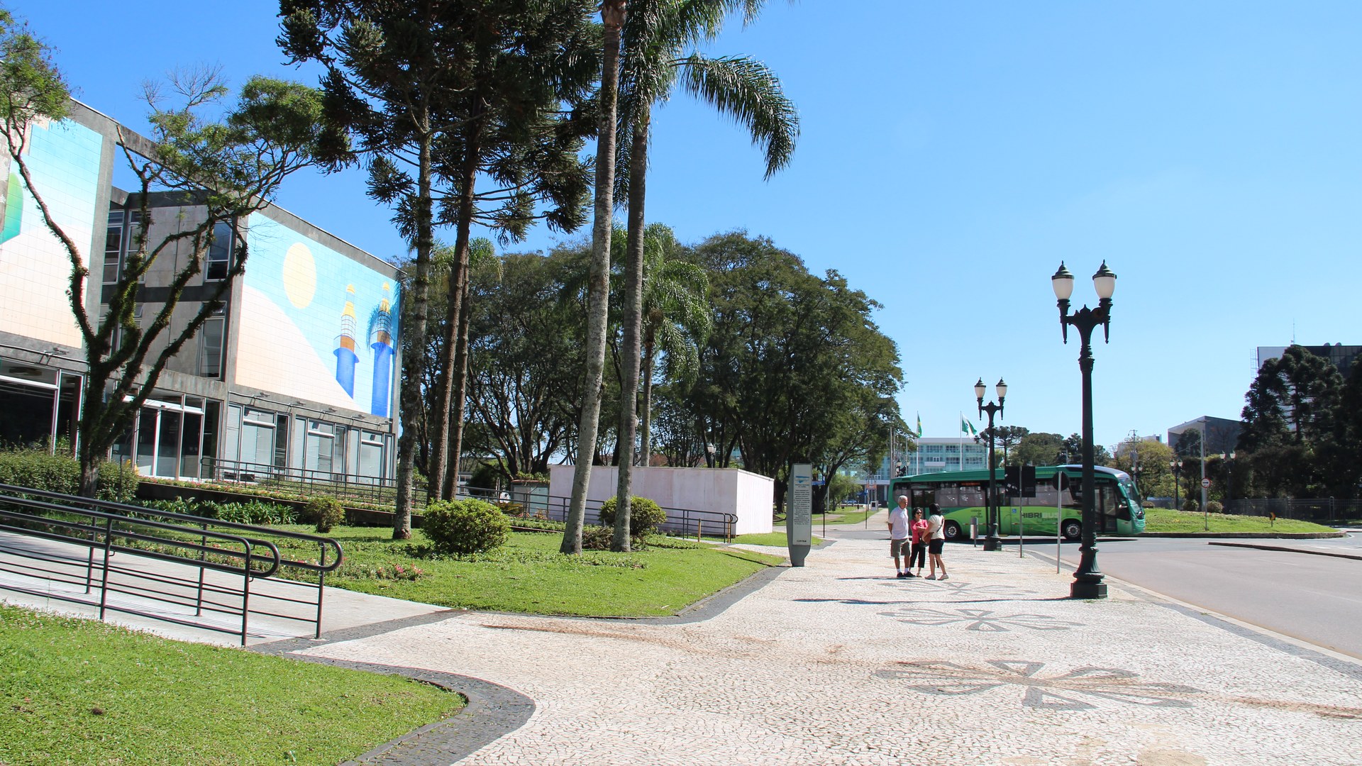Calçadão em pedra portuguesa no Centro Cívico de Curitiba, com a lateral do Palácio 29 de Março à esquerda e araucárias ao fundo